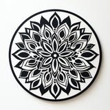 Black and white mandala with intricate floral and geometric patterns on a pale background